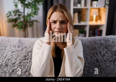 Sad blonde suffering from headache Stock Photo