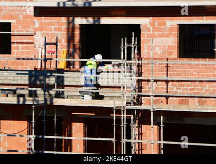 A construction worker rough bricklaying on a new block of flats on a sunny morning Santander Cantabria Spain Stock Photo
