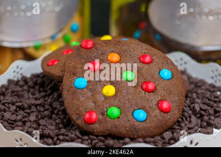 Multi-colored chocolate cookie Homemade on a bed of chocolate chips Stock Photo