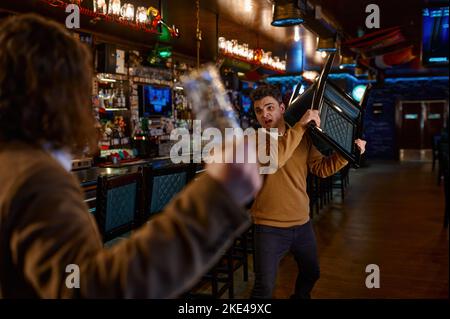 Two man hooligan football fans get in bar fight Stock Photo