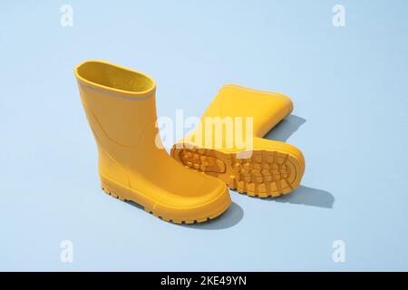 Yellow rubber boots isolated on blue background Stock Photo