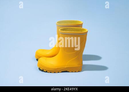 Yellow rubber boots isolated on blue background Stock Photo