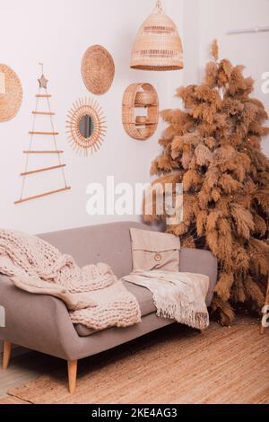 Stylish modern sofa in the home interior. Christmas tree made of dried flowers Stock Photo