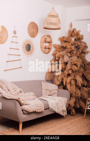 Stylish modern sofa in the home interior. Christmas tree made of dried flowers Stock Photo