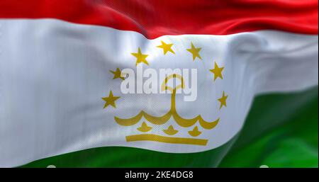 Close-up view of the Tajikistan national flag waving in the wind. The Republic of Tajikistan is a landlocked country in Central Asia. Fabric textured Stock Photo