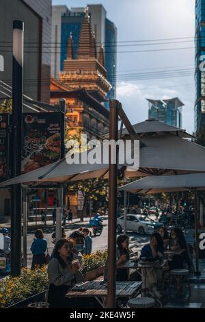 A vertical shot of office workers enjoying their break by taking a coffee with the Jing'an Temple in the background Stock Photo