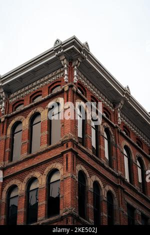 A vertical view of a red-tiled building with arc-shaped windows and a beautiful roof Stock Photo