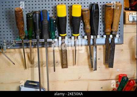 tools hanging on wall in workshop at home Stock Photo