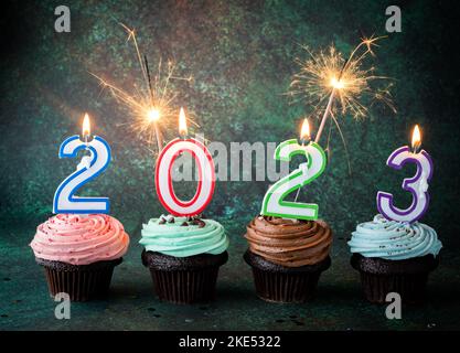 Cupcakes for the New Year with number lit candles and sparklers. Stock Photo