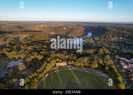 Aerial view of sporting ground, Sutherland Oval, Woronora River and Sutherland suburb surrounded by lush greenery, Sydney, NSW, Australia Stock Photo