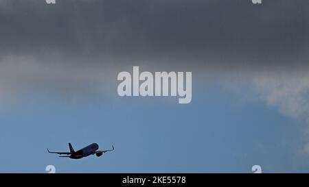 Munich, Germany. 10th Nov, 2022. An airplane flies towards dark cloud after its Sart at Munich airport. Credit: Angelika Warmuth/dpa/Alamy Live News Stock Photo