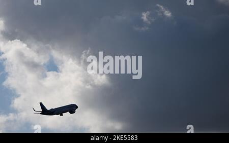 Munich, Germany. 10th Nov, 2022. An airplane flies towards dark cloud after its Sart at Munich airport. Credit: Angelika Warmuth/dpa/Alamy Live News Stock Photo