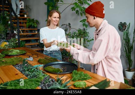 Young man and woman florist working at creative workshop Stock Photo