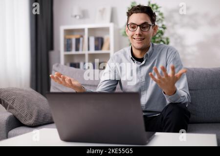 Man using laptop on couch Stock Photo