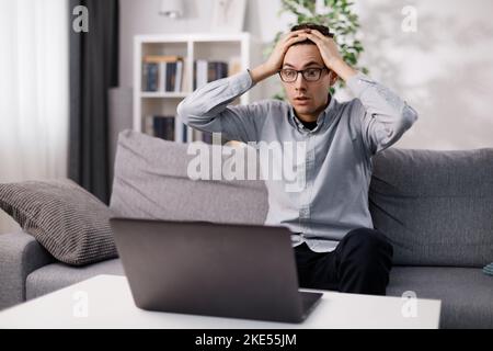 Shocked man looking on laptop Stock Photo