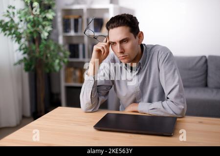 Pensive man using laptop Stock Photo