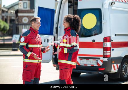 Cheerful ambulance doctors having a conversation outdoors Stock Photo