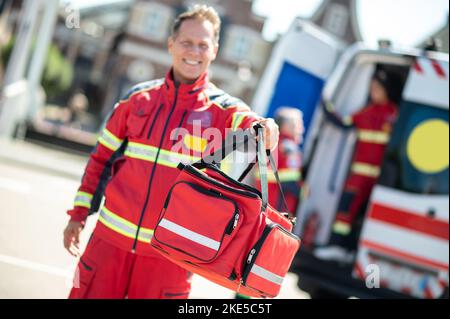 Smiling happy middle-aged paramedic finishing his shif Stock Photo