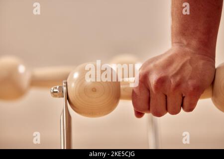 Man doing a handstand push-up using floor bars balancing on his hands. Health and fitness concept. Stock Photo