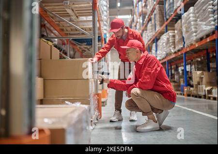 Experienced warehouse personnel involved in cargo handling Stock Photo