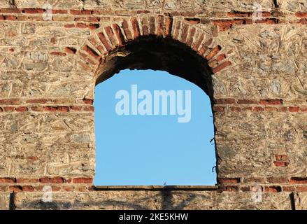 oval window in brick building opening to sky, aged round window, old ottoman build Stock Photo