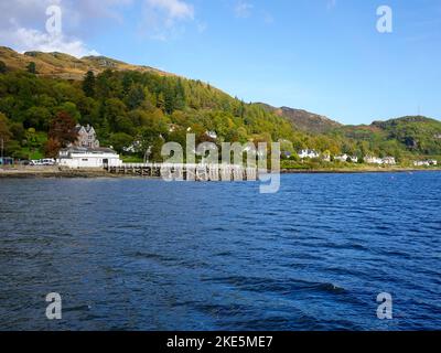 People fishing from a pier and homes of Tignabruaich, Kyles of Bute, on the Cowal Peninsula, Scotland, UK. Stock Photo