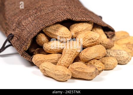 Peanuts in a jute bag against a white background Stock Photo