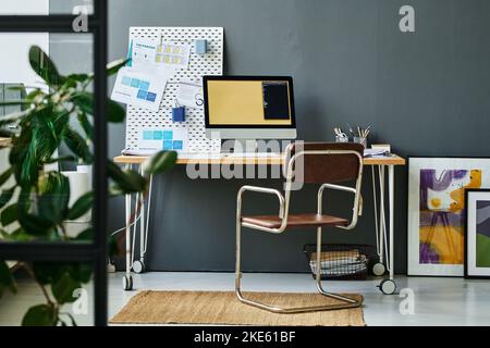 Workplace of modern white collar worker or creative designer with computer monitor and noticeboard with financial documents Stock Photo