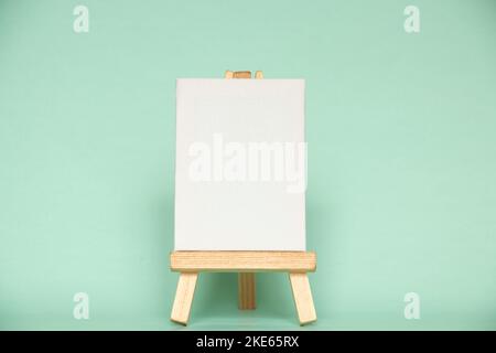 Premium Photo  Wooden easel stands on a stand against the backdrop of a  building and a beautiful green spruce