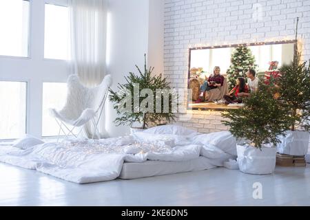 New Year's interior. Christmas tree bed with soft beige back and decorative pillows. Concept happy Cristmas. Stock Photo