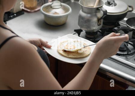 https://l450v.alamy.com/450v/2ke6jb5/latina-woman-preparing-a-typical-colombian-breakfast-of-arepa-with-egg-girl-in-her-kitchen-preparing-food-2ke6jb5.jpg