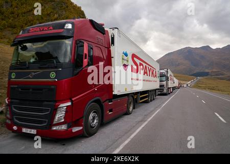 Kazbegi, Georgia - October 3, 2022: Several kilometres long line of Trucks by the side of the Georgian military highway near Kazbegi waiting for cross Stock Photo