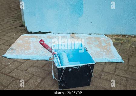 Roller with blue paint. DIY concept. incorrect wall painting Stock Photo