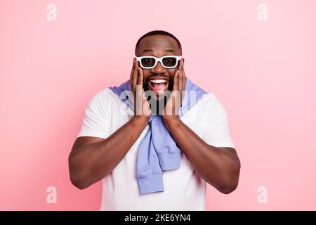 Photo of young impressed crazy man can't stop laughing watching funny 3d film isolated on pink color background Stock Photo