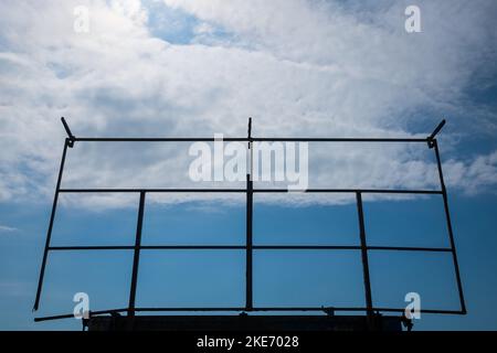 An old rusted steel billboard frame in a blue sky background Stock Photo