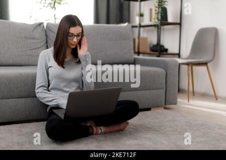 Brunette studying on laptop Stock Photo