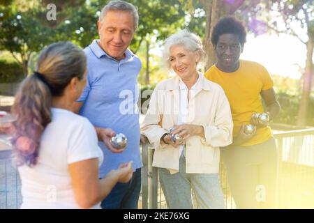 Mature petanque players share their impressions of their game Stock Photo