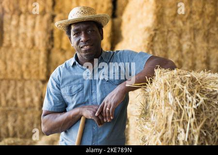 Portrait of a concentrated african american male standing near a haystack Stock Photo