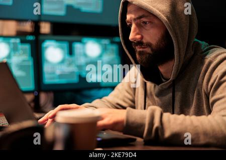 Dangerous IT criminal working on security breach, creating cyber attack on big data server. Hacking computer system and software, breaking security firewall and stealing company information. Stock Photo