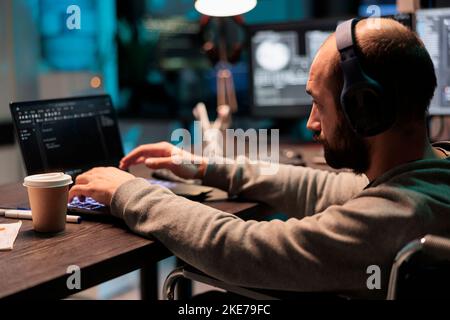 Web developer with physical disability writing code, computing big data to create app interface. Using html script and database source to program artificial intelligence algorithm. Stock Photo