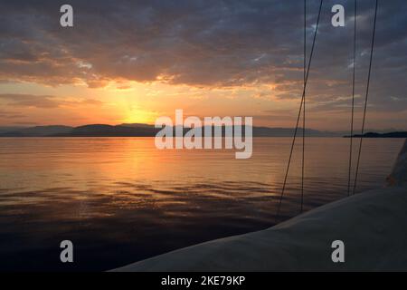 Sailing in the ionian sea during sunrise. Stock Photo