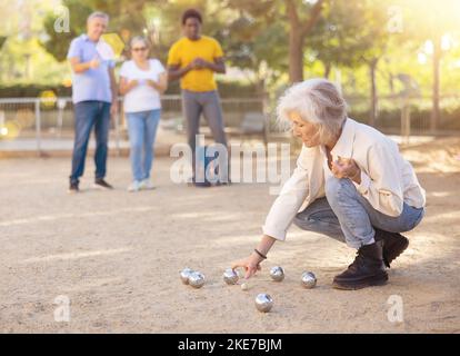 Mature people playing petanque on sand together Stock Photo - Alamy
