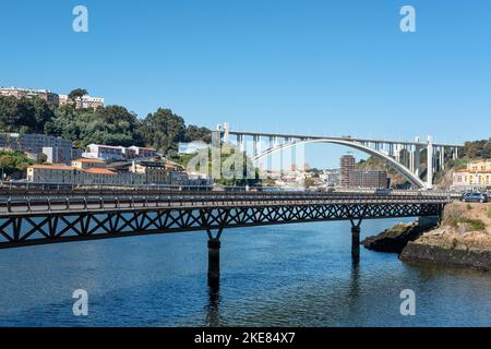 Views of the Douro riverside with Viaducto do Cais das Pedras in the foreground and Ponte da Arrabida, one of the six arch bridges in the city Stock Photo