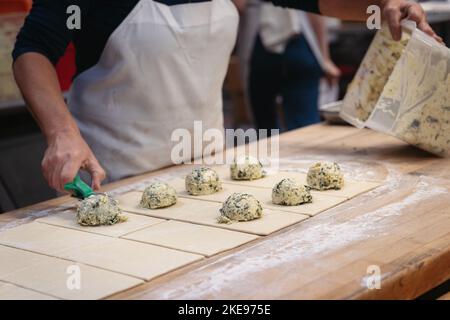 a professional baker scoops out filling for a puff pastry Stock Photo