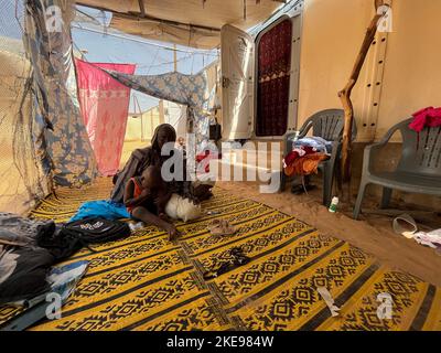 St. Louis, Senegal. 31st Oct, 2022. Fisherman Mary Diop Seck sits with one of his children outside the tent at the Diougoup tent city in St. Louis. Credit: Lucia Weiß/dpa/Alamy Live News Stock Photo