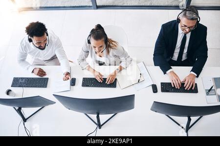 Team, call center and customer support agents from above working on a sales strategy in the office. Crm, contact us and customer service consultants Stock Photo