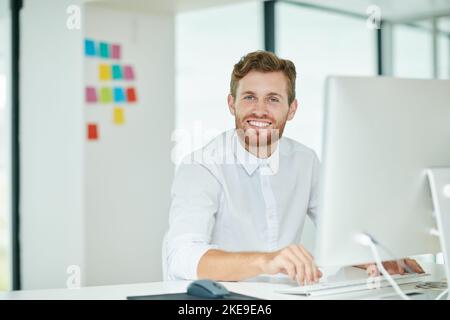 Im constantly raising the bar. a businessman working on his computer in the office. Stock Photo