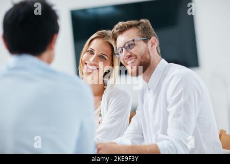 His ideas always benefit the team. a group of businesspeople discussing ideas together in the office. Stock Photo