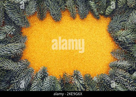 Golden glitter texture framed by Christmas tree branches Stock Photo