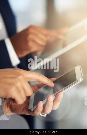 Smart business demands smart devices. businesspeople using their tablets and phones at work. Stock Photo